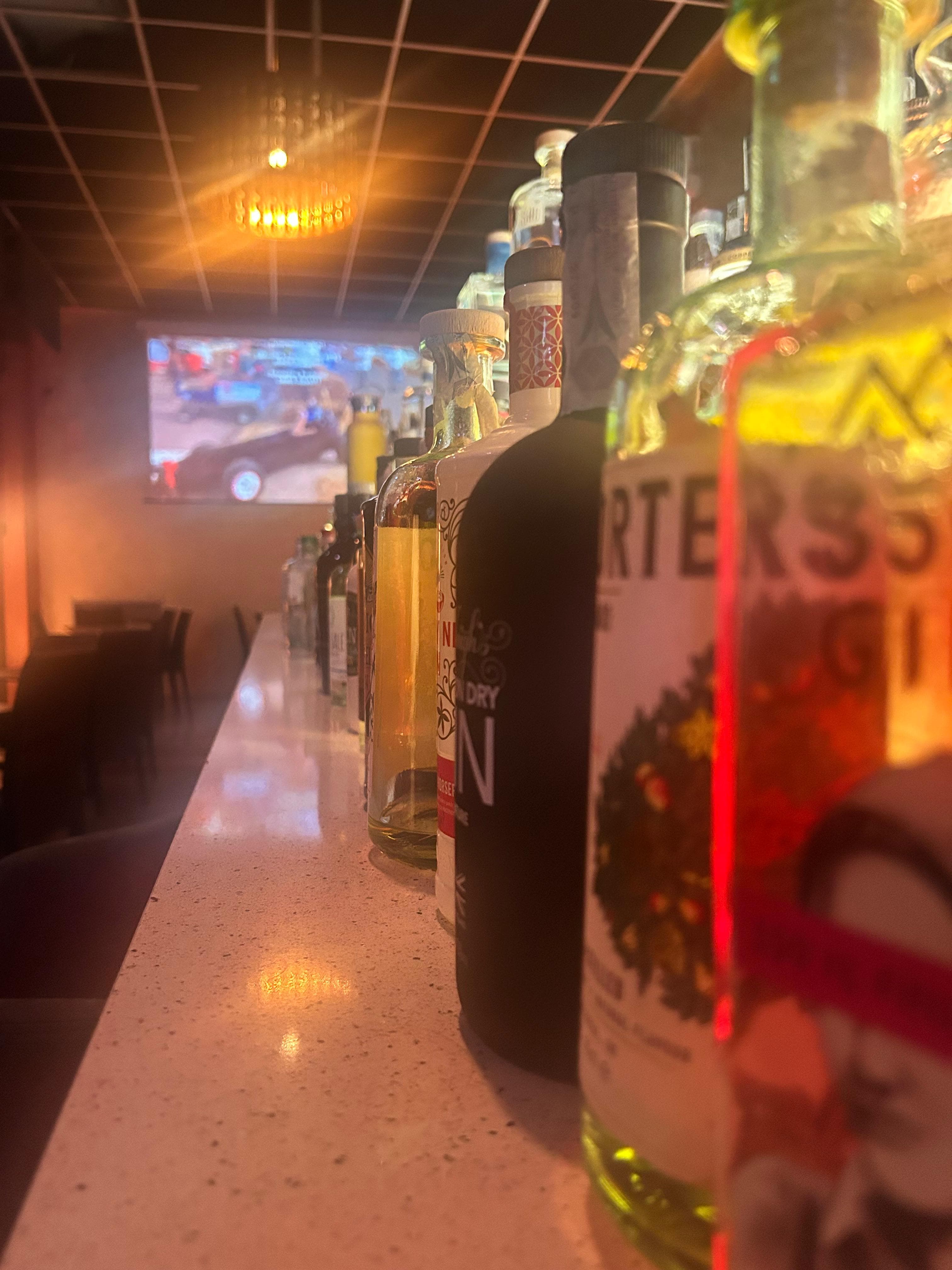 Dettaglio del bancone con bottiglie di gin in fila